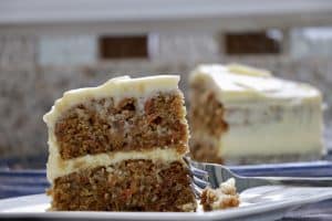 a piece of carrot cake with a fork on a plate